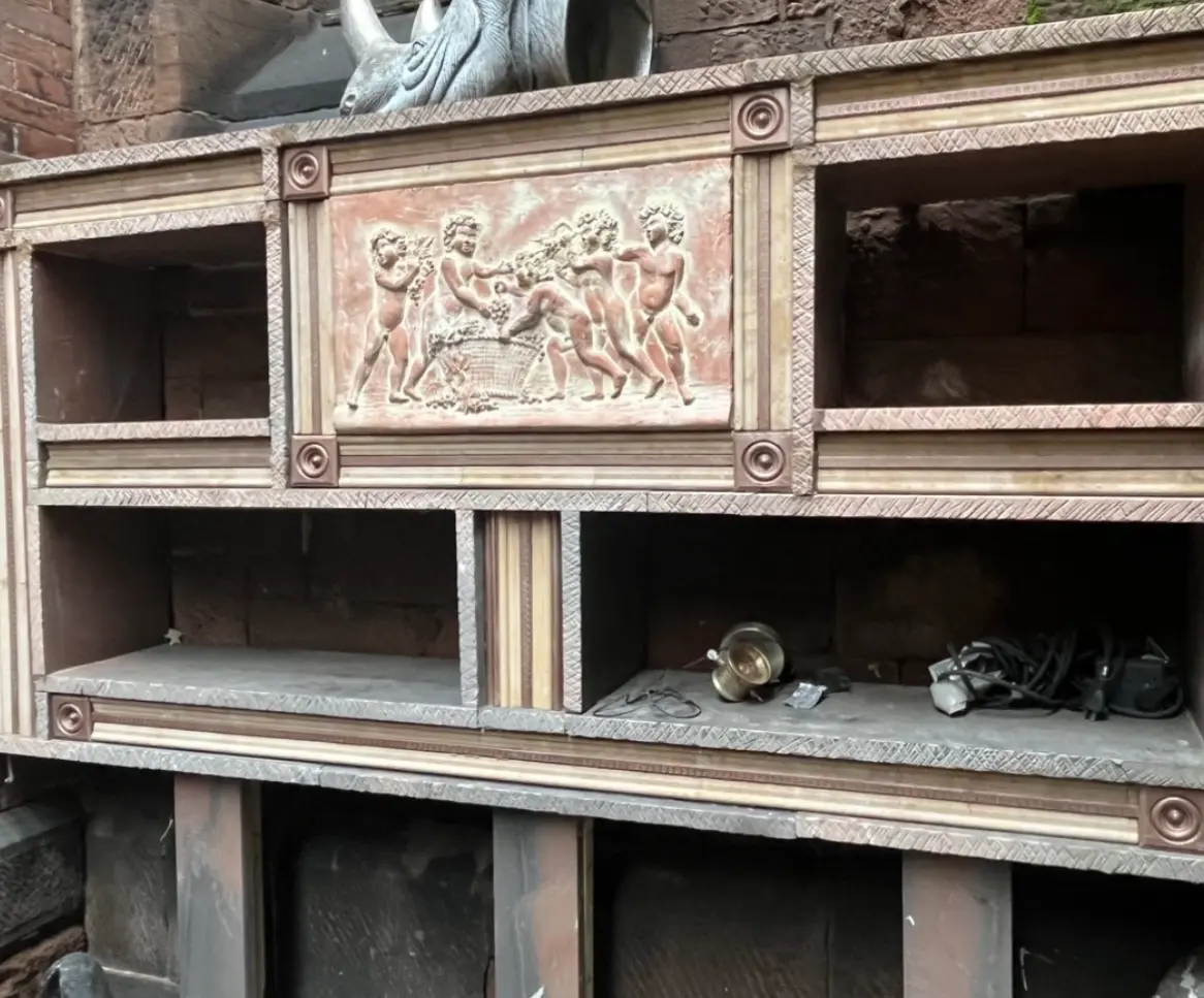 Custom stone shelving unit with carved classical figures relief panel