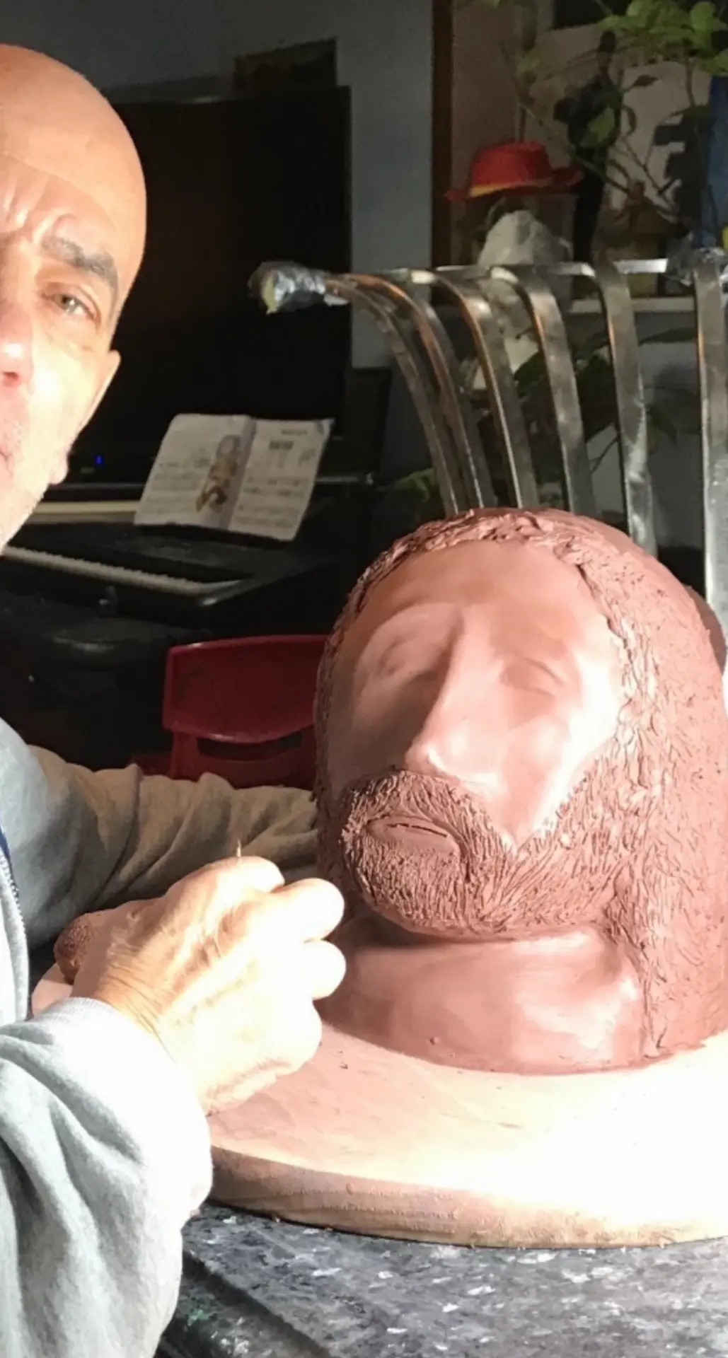 Sculptor refining a clay portrait bust in the studio