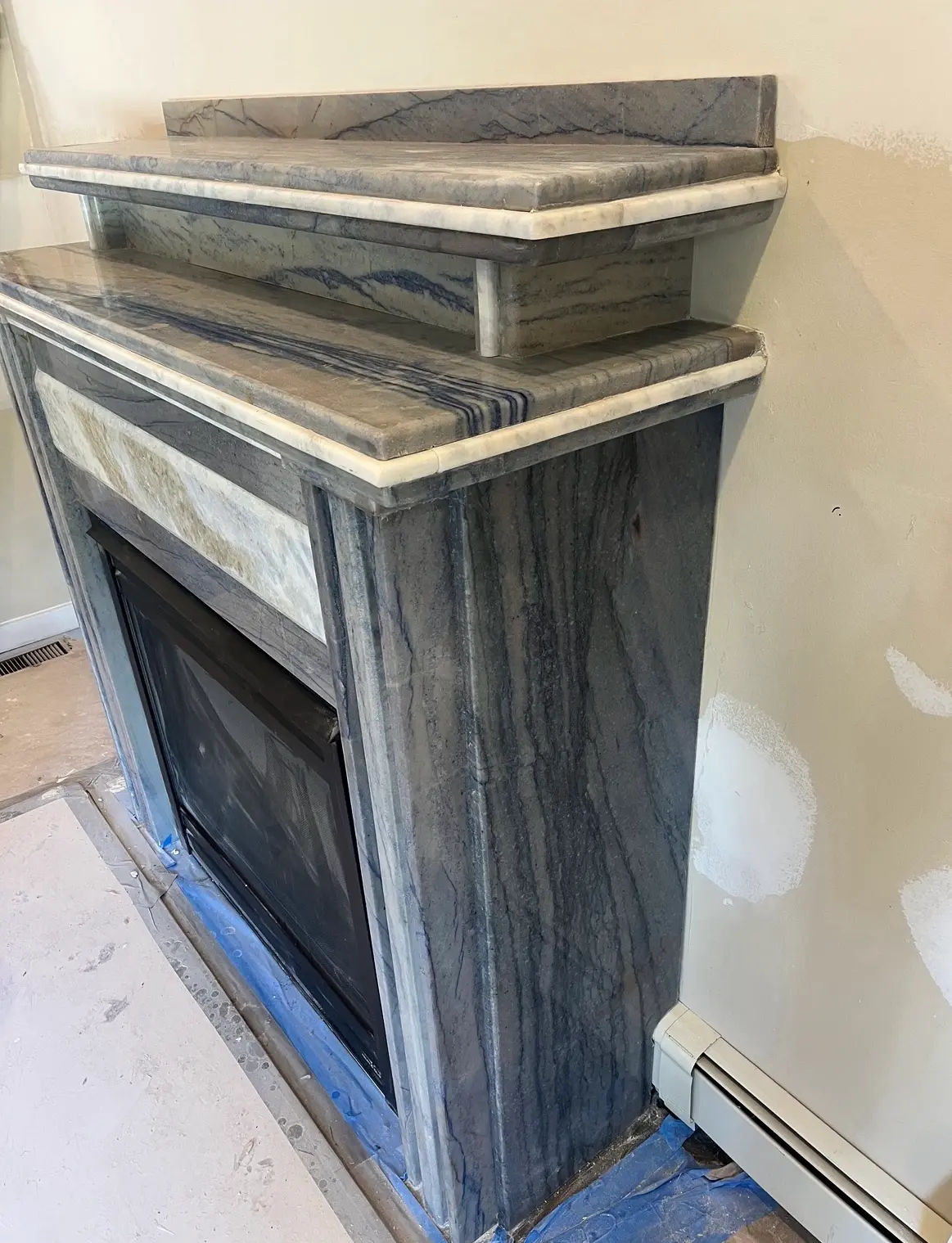 Grey veined marble fireplace surround with matching marble shelving
