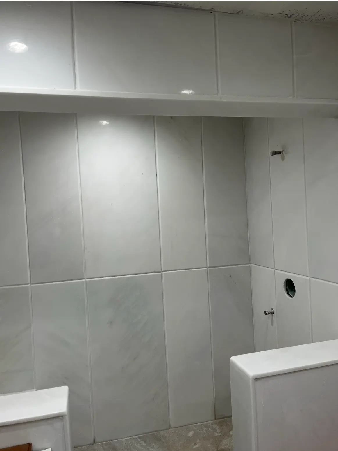 Bathroom walls in large white marble tiles with trim molding