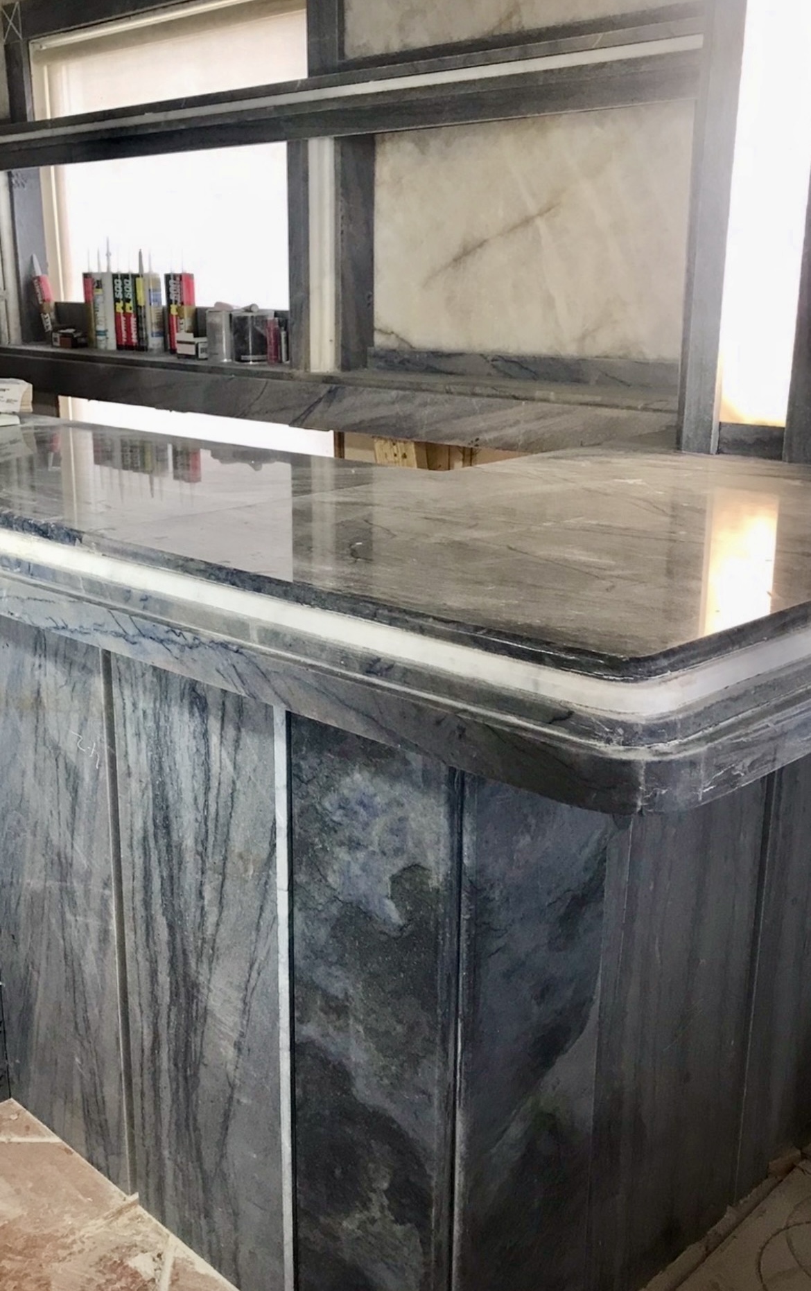 Marble bar counter in blue-grey stone with white banding and profiled edge
