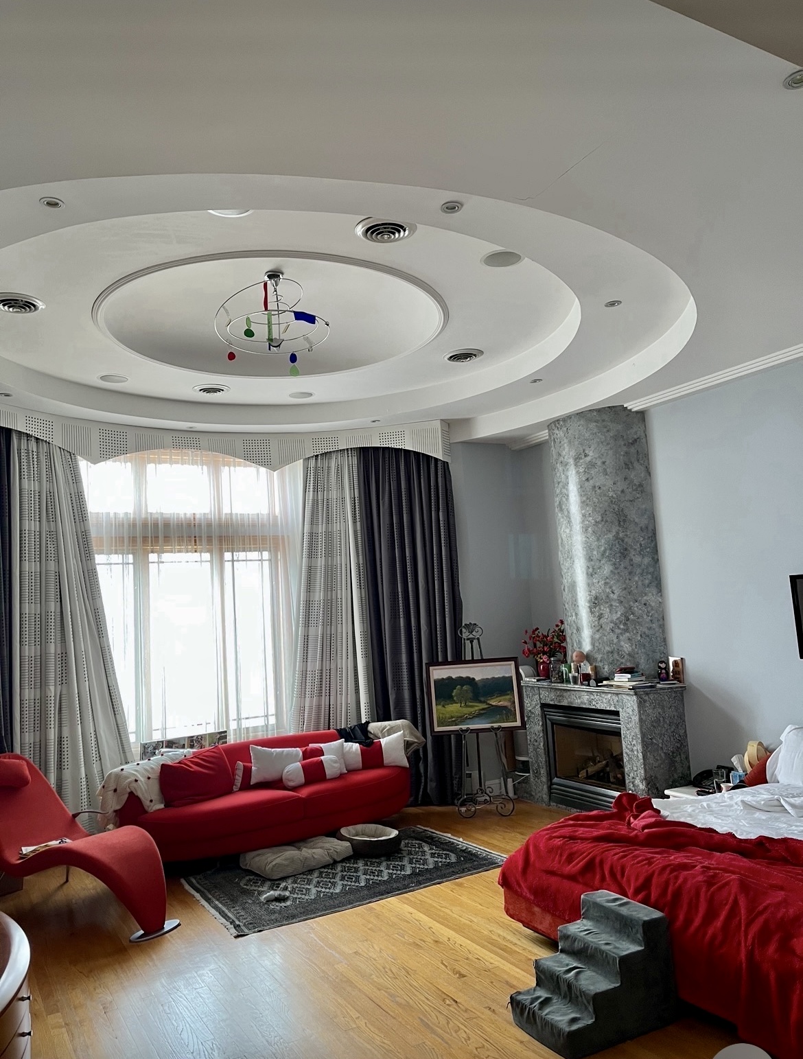 Circular bedroom with grey marble wrapped column and fireplace