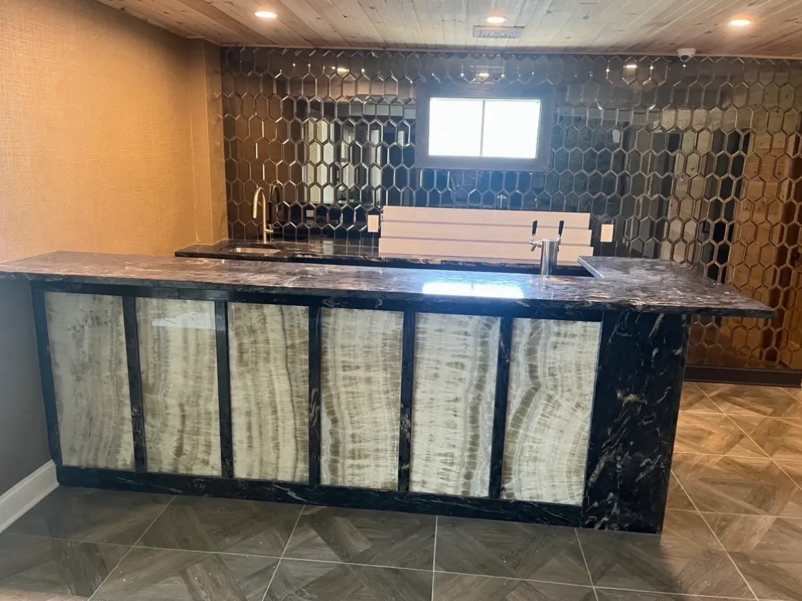 Basement bar front with illuminated onyx panels and dark granite countertop
