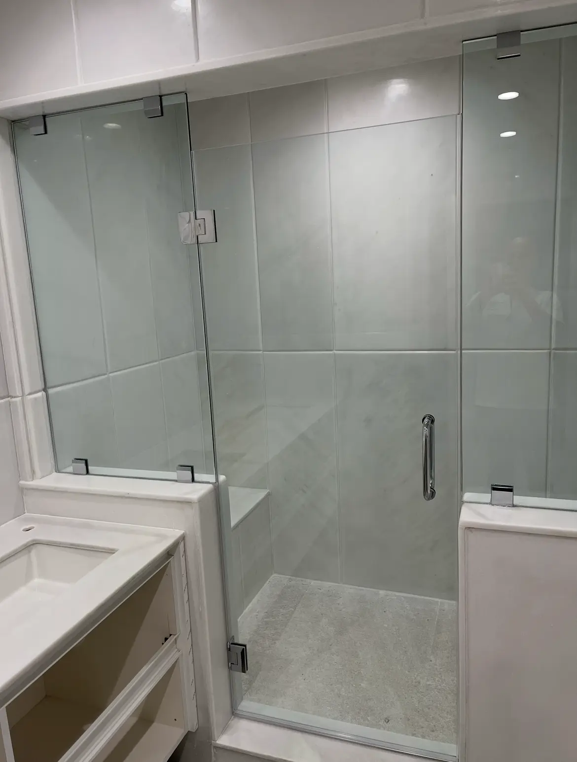 Bright white marble shower enclosure with frameless glass door