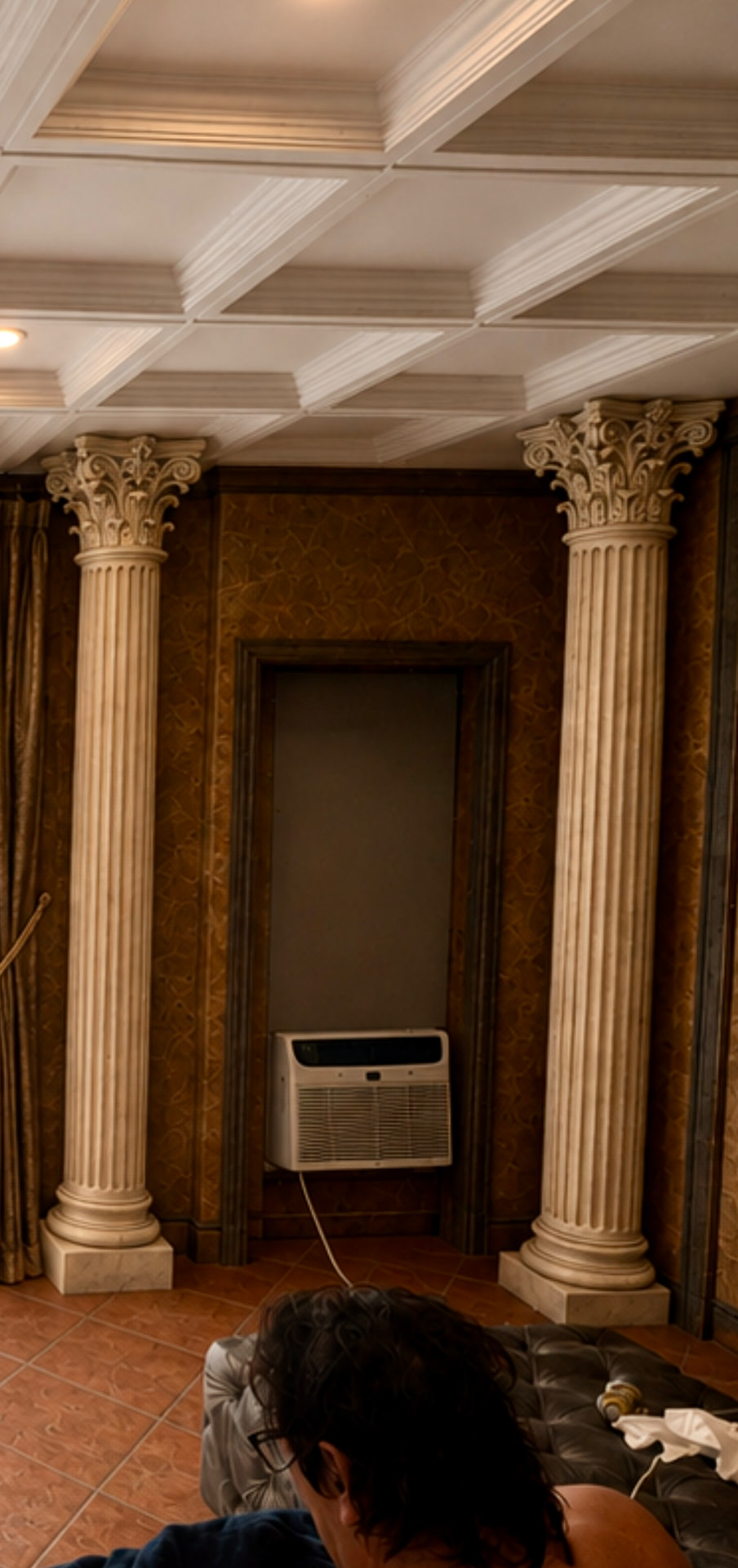 Pair of fluted stone columns with carved Corinthian capitals in a paneled room