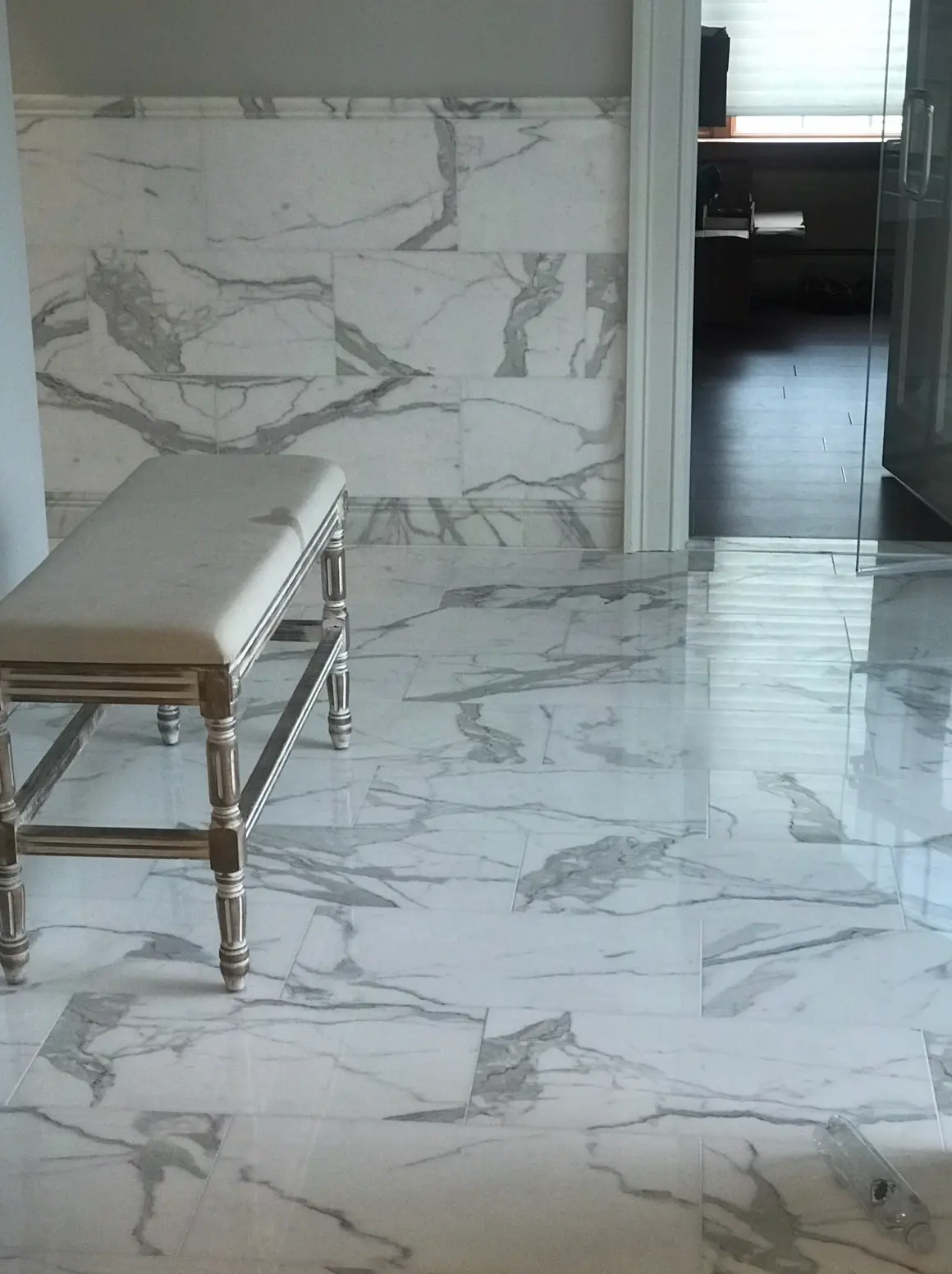 Polished marble floor with matching marble wall tiles and bench