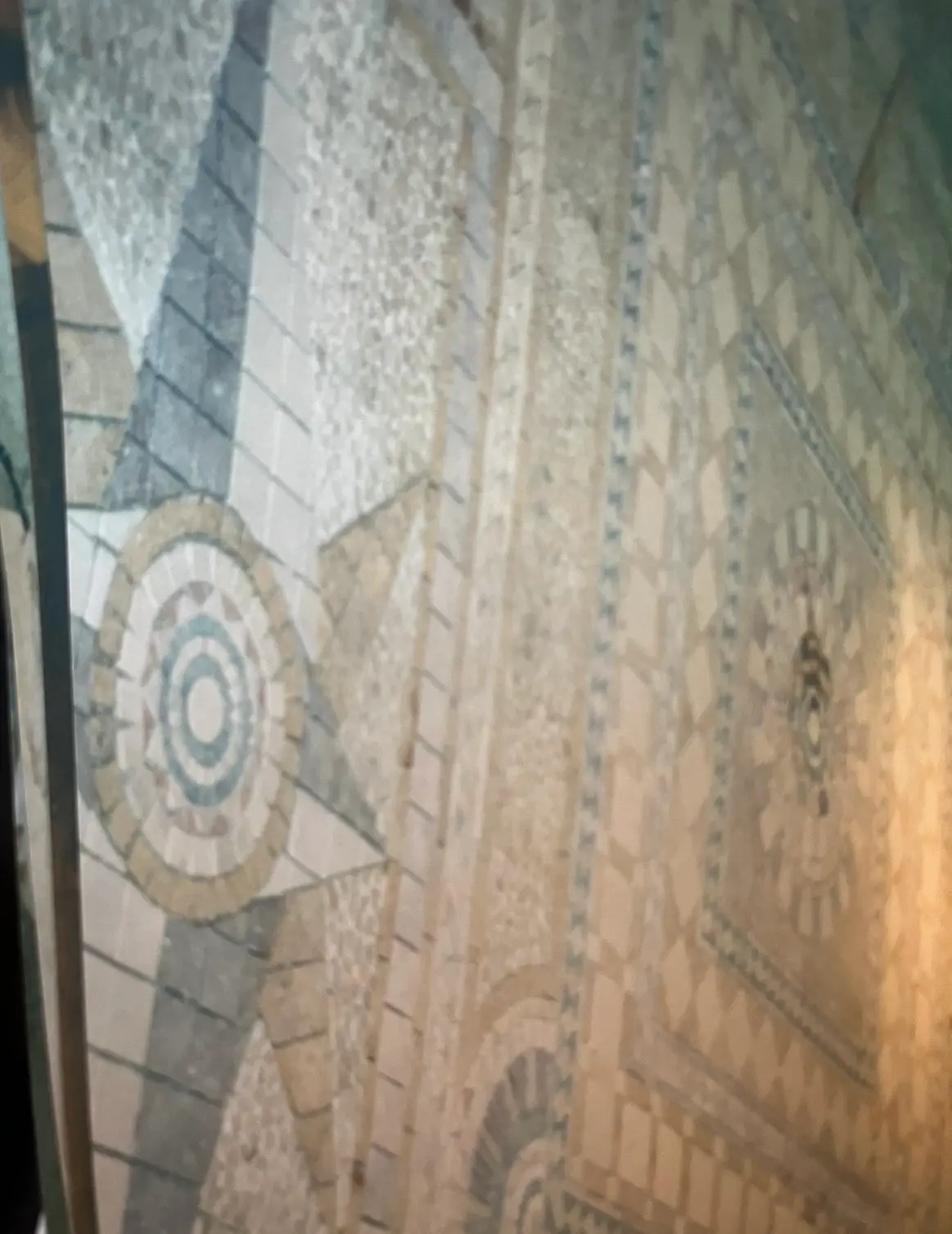 Intricate stone mosaic floor with circular medallion and patterned borders