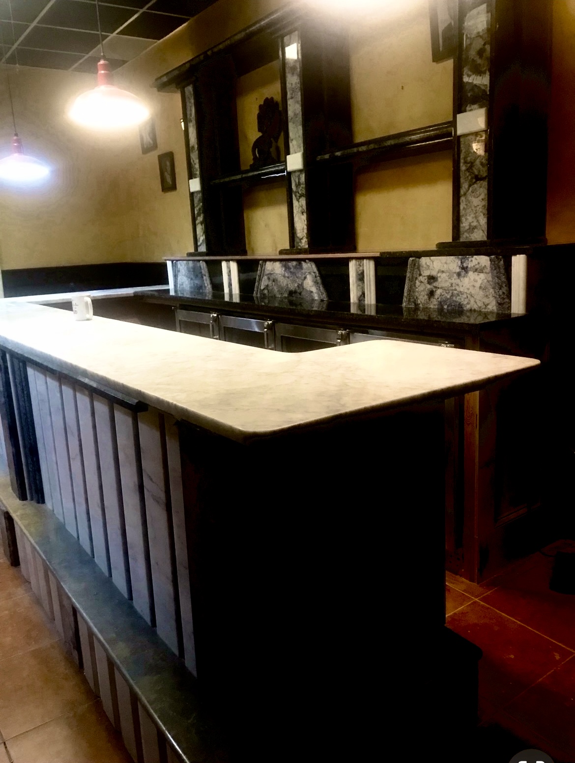 L-shaped bar with white marble top and dark granite back counter