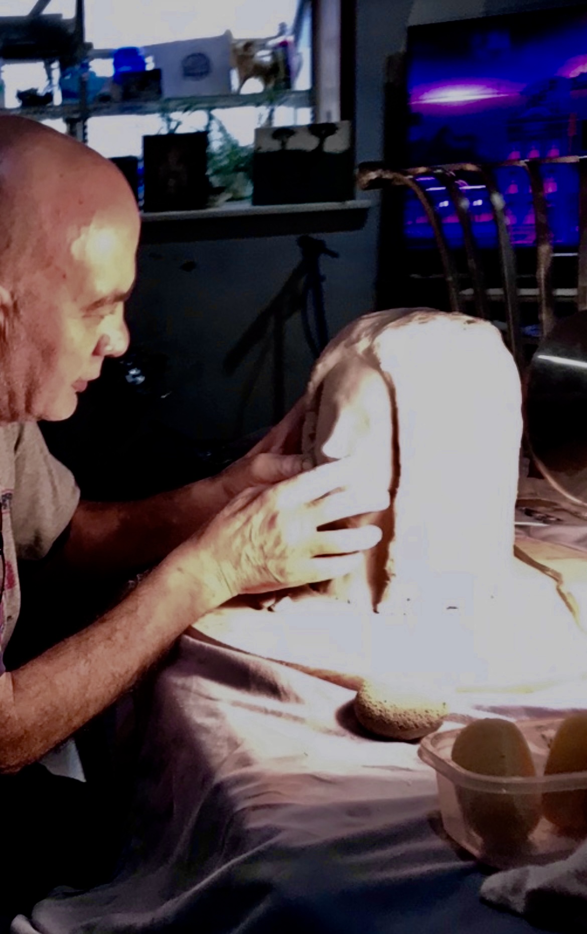 Craftsman hand-shaping a sculpted stone form in the Pompei fabrication shop