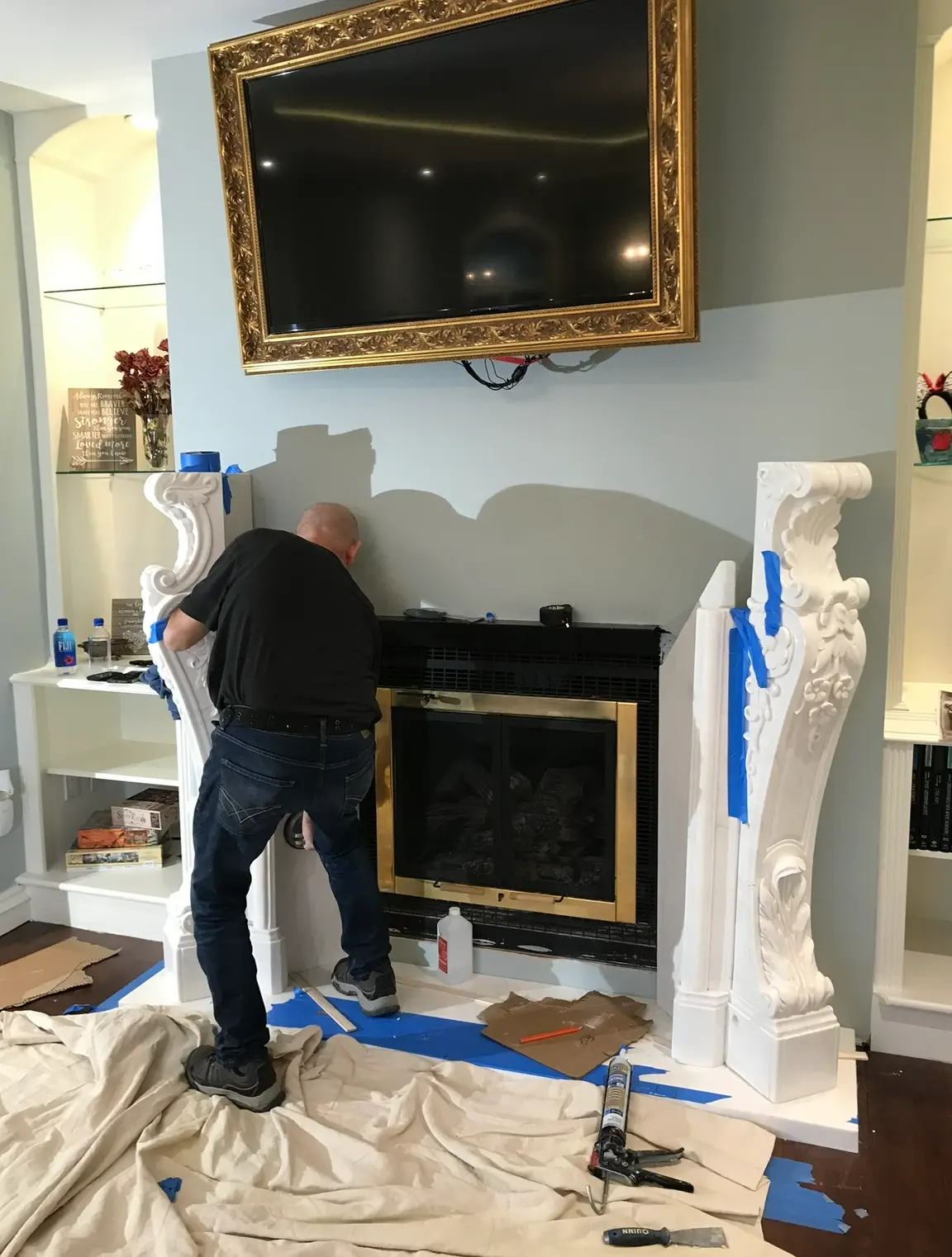 Installer positioning a carved white marble fireplace mantel leg
